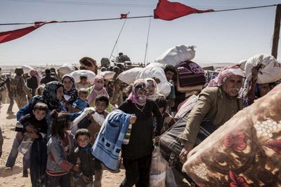 Refugiados curdos da Síria cruzam a fronteira em direção à Turquia, próxima da cidade de Kobani. Crédito: ACNUR