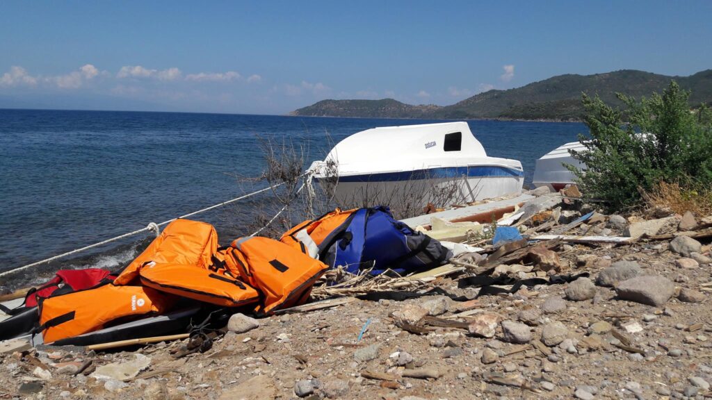 Praia na costa norte de Lesvos. Os coletes pertenciam a refugiados/migrantes que haviam feito a travessia recentemente. Crédito: Bruna Kadletz