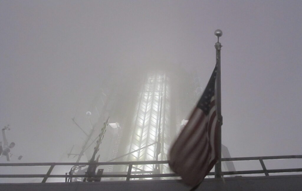 Bandeira dos EUA no Empire State Building, em noite de nevoeiro. Uma foto que traduz o cenário de incerteza que se desenha. Crédito: Rodrigo Borges Delfim - mai.2013/MigraMundo