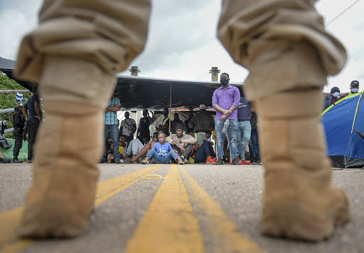 Policiais peruanos bloqueiam ponte que liga o Peru ao Brasil, na qual imigrantes acampam em protesto